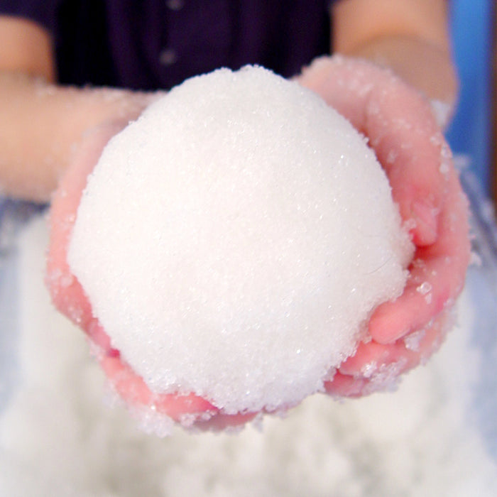 Close-up of hands holding a snowball against a blurred background