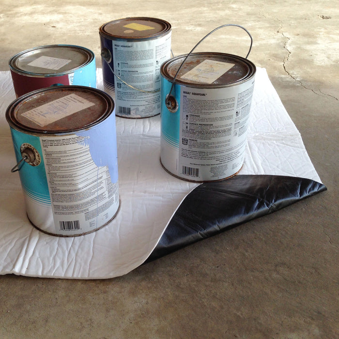 Four open paint cans on a white stay put pad with a concrete floor background